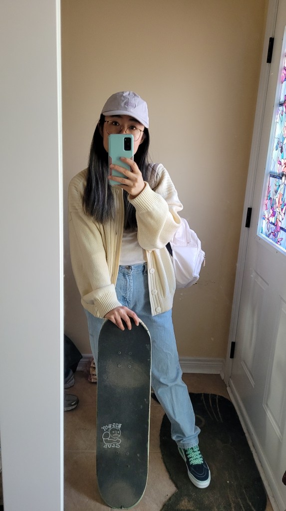 Outfit of the day selfies before heading out for a skateboard session - pastel purple baseball cap from roots, oversized slouchy cream bomber cardigan with white t-shirt, light blue vintage mom jeans, Vans sneakers with green lace and skateboard. 