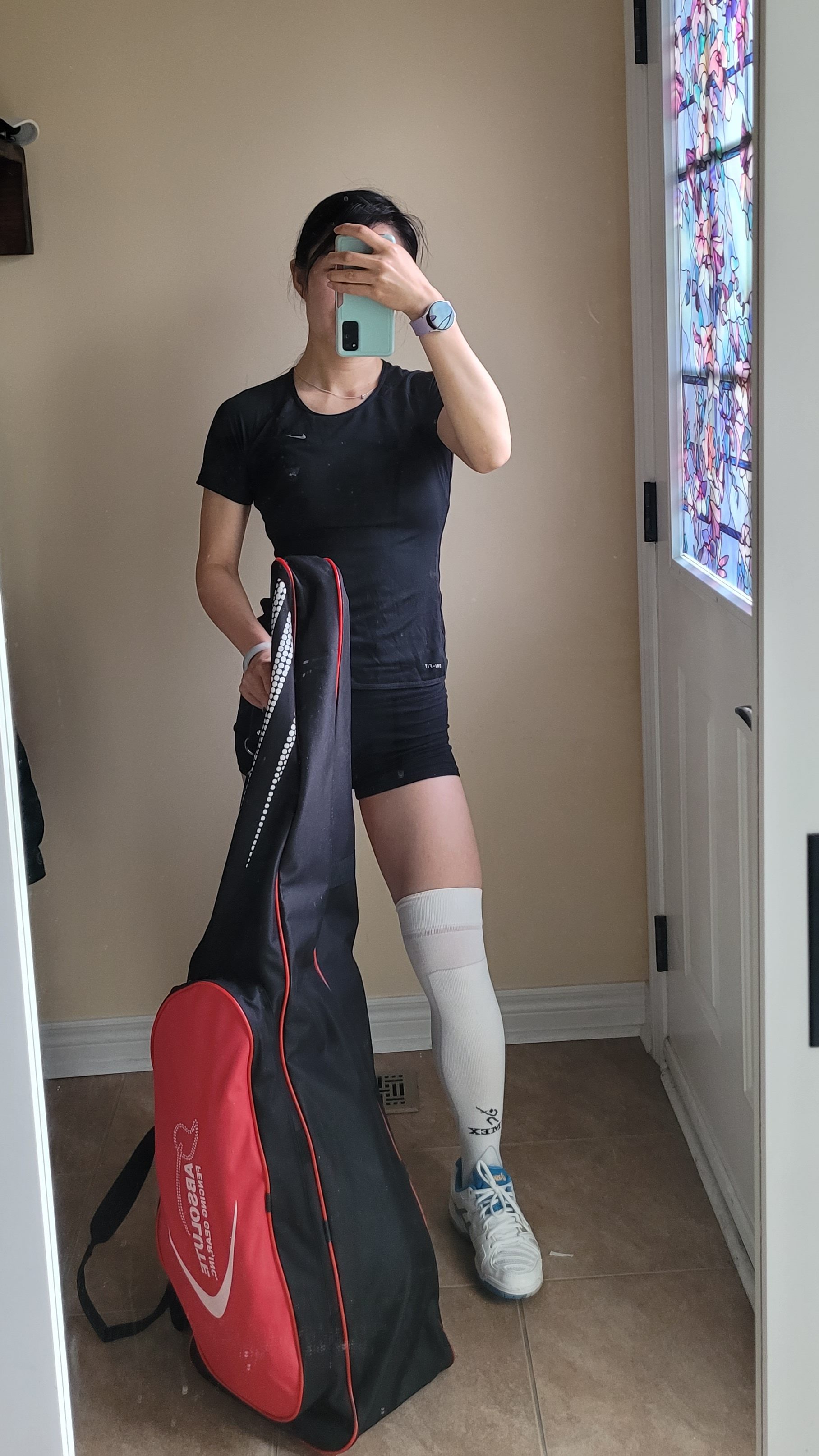 Outfit of the day selfies before heading out for fencing - black form fitting short sleeve athletic top and shorts, knee-high fencing socks with court shoes and large fencing bag.